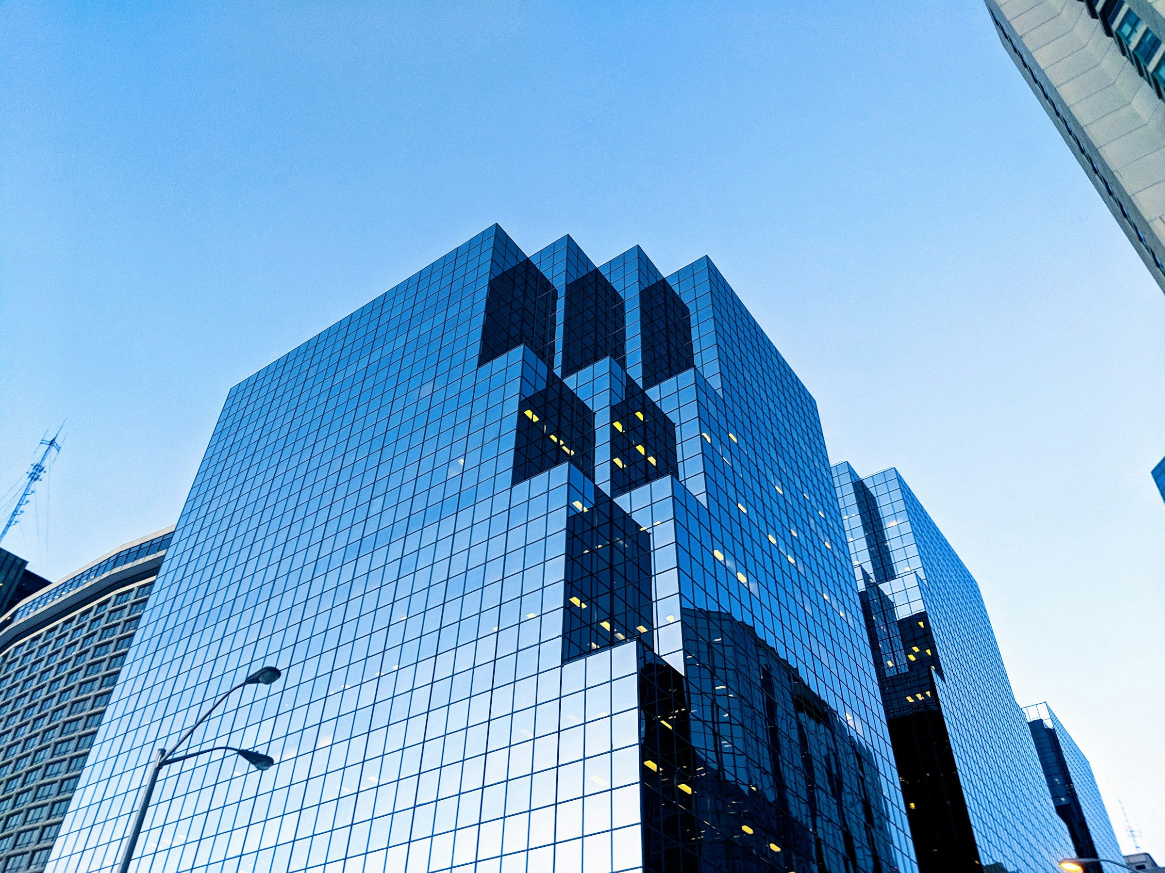 Glass office tower with reflective blue windows, viewed from below